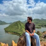 Panoramic view from Bahubali Hills in Udaipur, showing the tranquil blue waters of Badi Lake framed by the rugged Aravalli mountains at sunset.