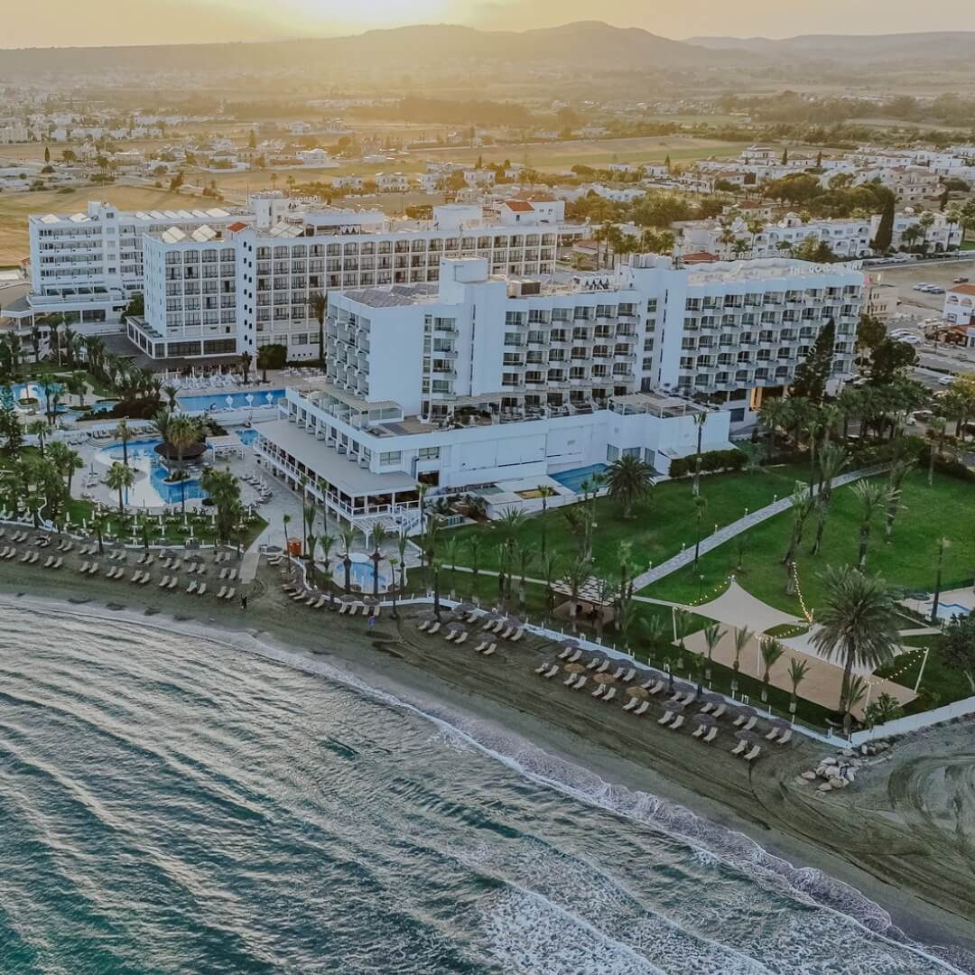 A modern luxury hotel room with a large bed, plush seating, and expansive windows offering a panoramic city view.