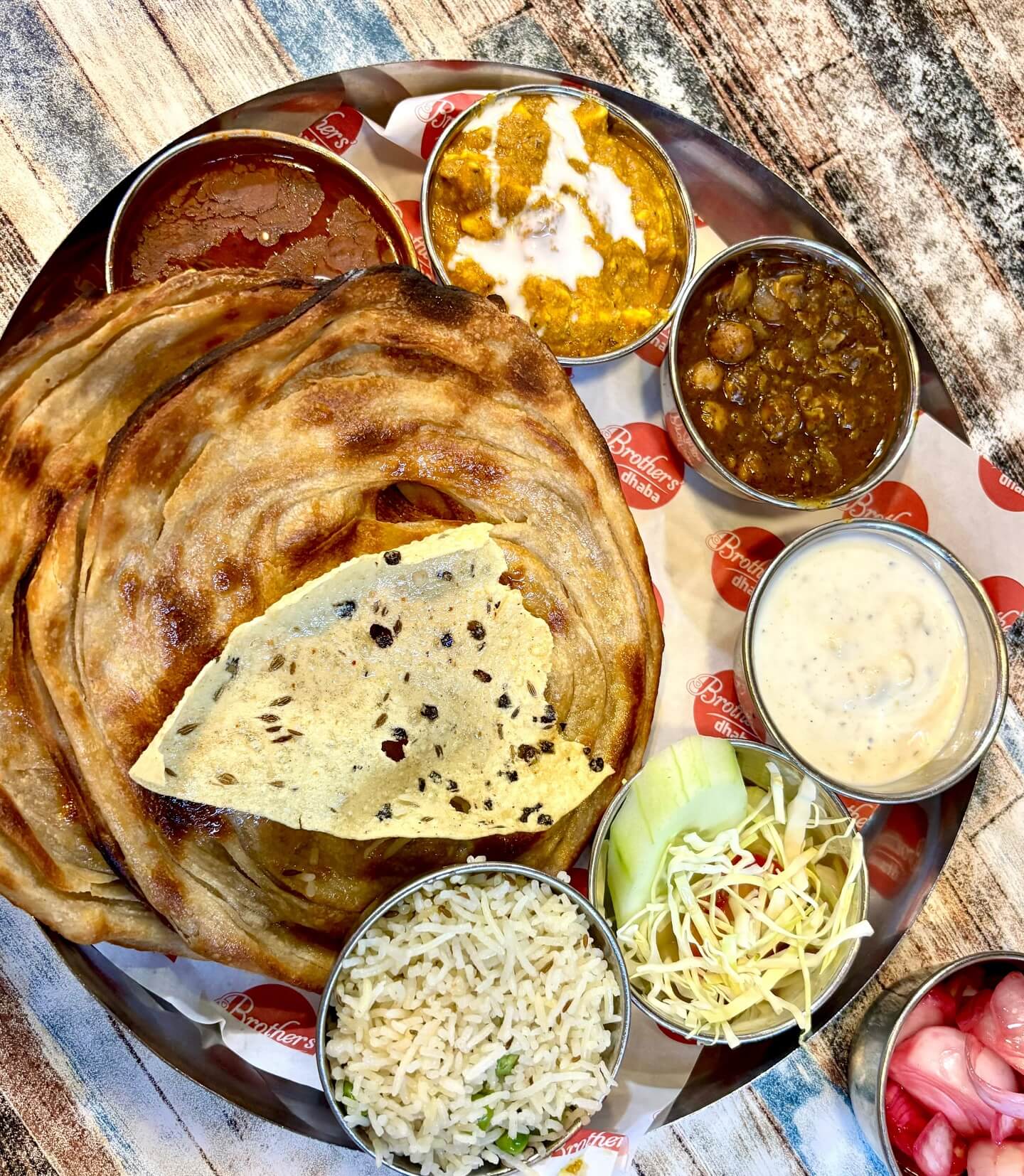 A vibrant plate of Amritsari kulcha served with chole and topped with butter.