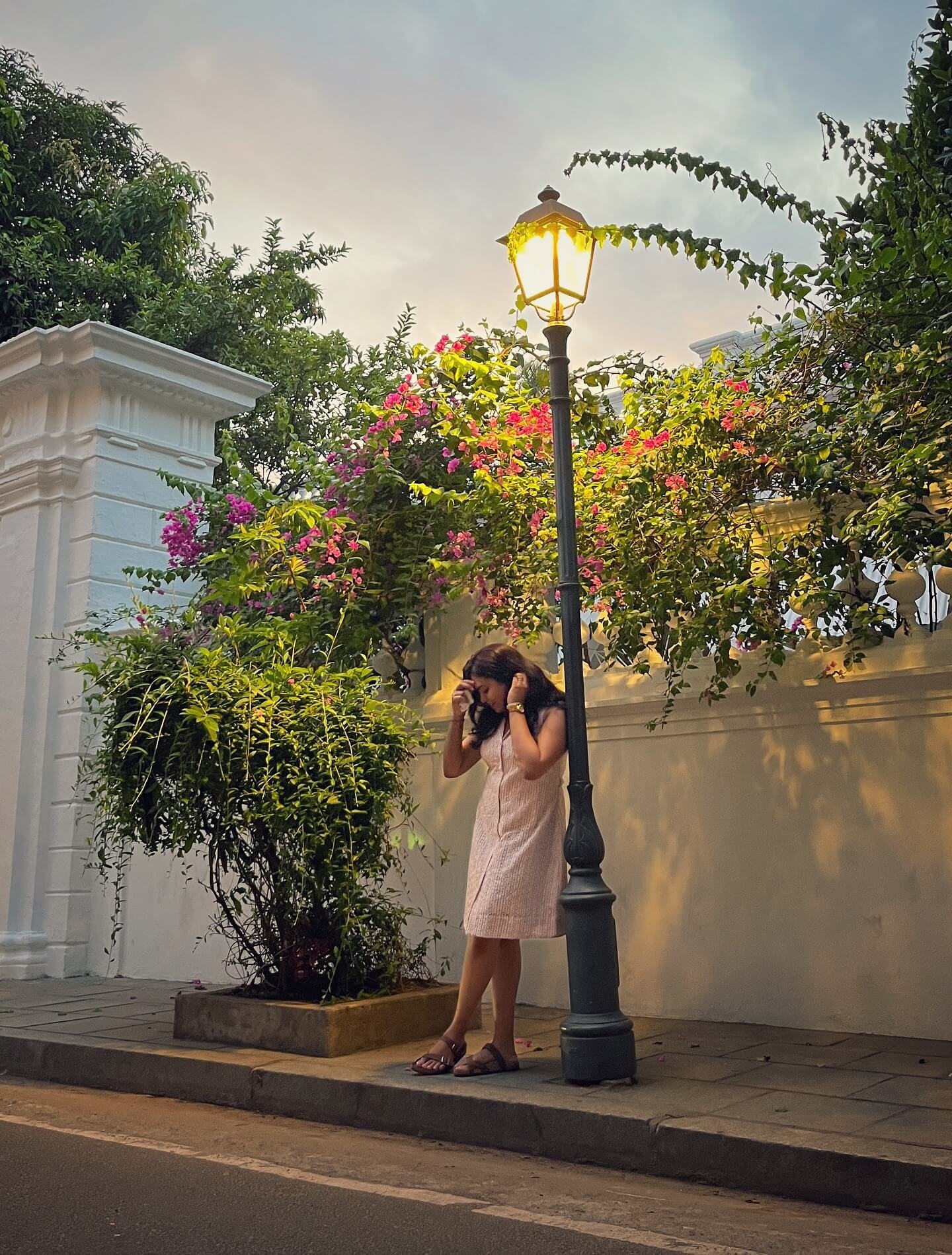 A street in the French Quarter of Pondicherry with a brightly colored building and a bougainvillea tree.