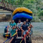 A group of people in a white water raft navigating a series of rapids on a river,