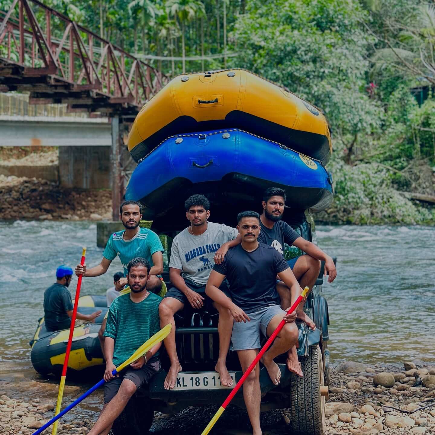 A group of people in a white water raft navigating a series of rapids on a river,