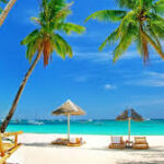 Tourists relaxing on a sunny beach in Goa during peak winter season.