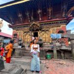 An exterior shot of the Changu Narayan Temple in Nepal, a historic Hindu temple with a two-tiered pagoda roof and intricate wood and stone carvings.