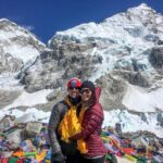 A collage of images from a Nepal honeymoon, featuring a couple in front of the snow-capped Himalayas, a scenic view of a lake with a boat, and a couple riding an elephant.