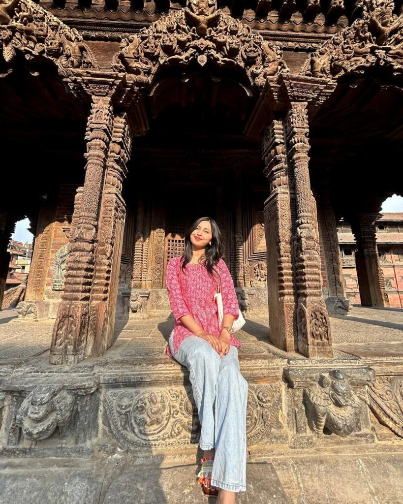 An exterior shot of Rani ki Vav, a large, intricate stepwell in Patan, with multiple levels of carved stone statues and pillars leading down to the water, under a bright sky.