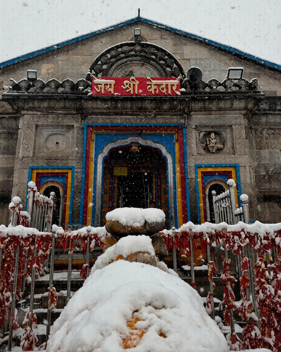 "The ancient stone structure of Kedarnath Temple in Uttarakhand, India, surrounded by snow-capped Himalayan peaks under a clear blue sky, capturing the spiritual essence of the 2026 Yatra opening."