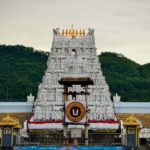 A beautiful view of the sacred Tirumala Venkateswara Temple in Tirupati with devotees standing in line for darshan, surrounded by hills and spiritual ambiance in Andhra Pradesh.