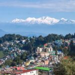 Darjeeling trip plan with scenic view of Kanchenjunga mountains, tea gardens, and toy train in Darjeeling, West Bengal