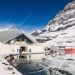 Trekkers and pilgrims walking on the Hemkund Sahib Trek route surrounded by Himalayan mountains and waterfalls