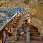 Adventure travelers walking on the famous wooden cliffside pathway during the Gartang Gali Trek in Uttarkashi, Uttarakhand surrounded by stunning Himalayan mountains.