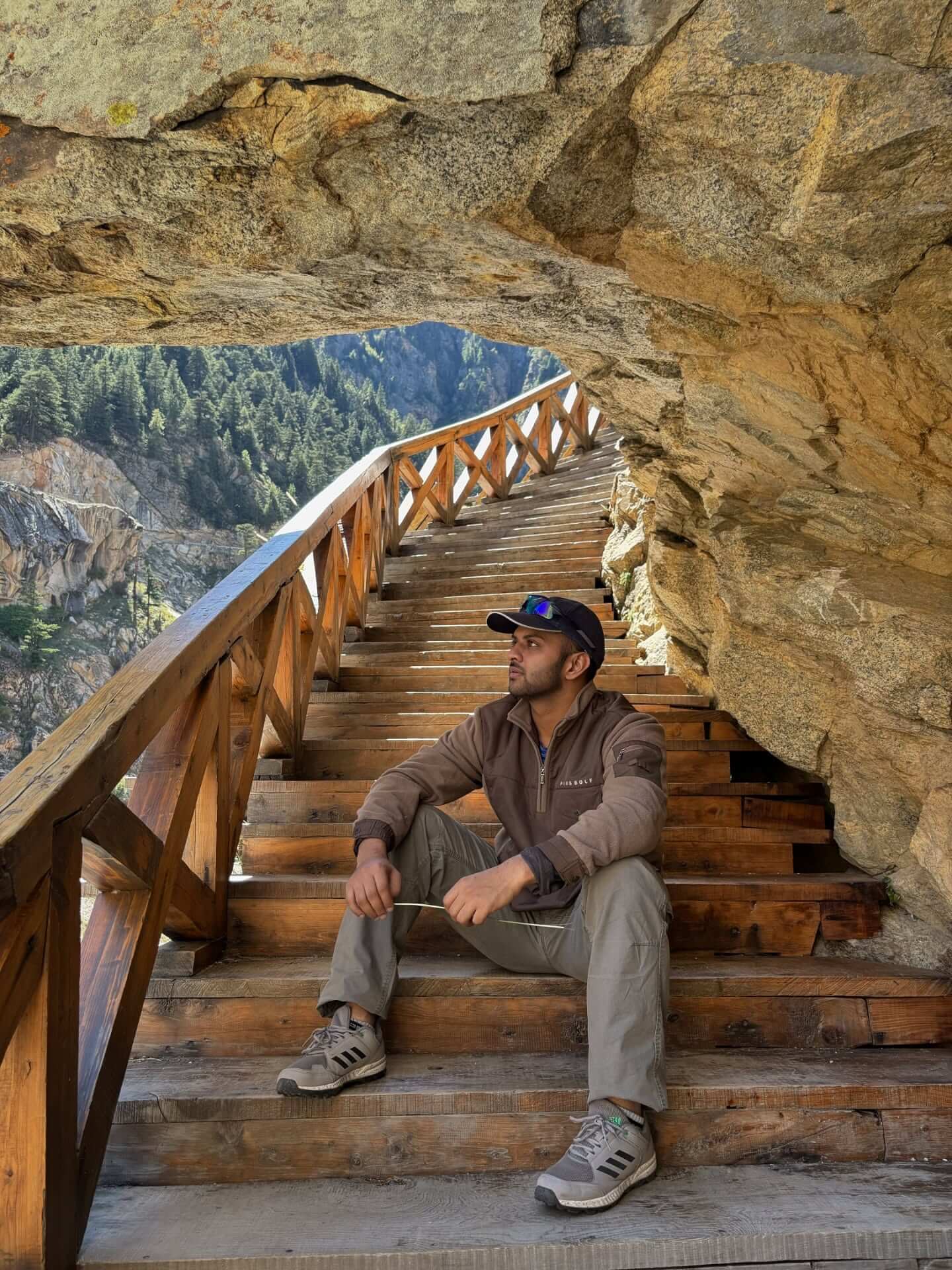 Adventure travelers walking on the famous wooden cliffside pathway during the Gartang Gali Trek in Uttarkashi, Uttarakhand surrounded by stunning Himalayan mountains.