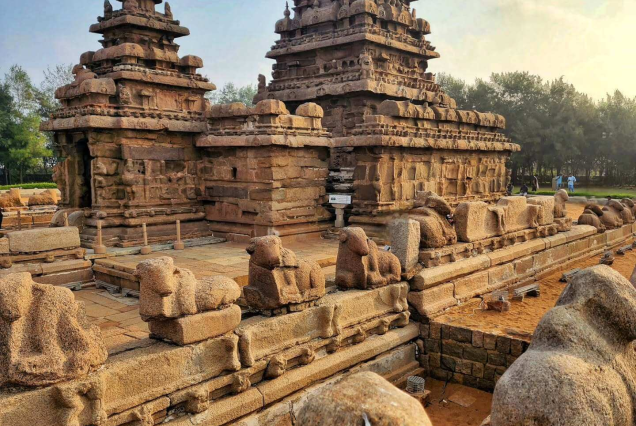 Ancient 8th-century stone Shore Temple in Mahabalipuram with pyramidal granite towers under a clear blue sky